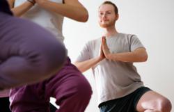 Man in ypga pose in yoga class.
